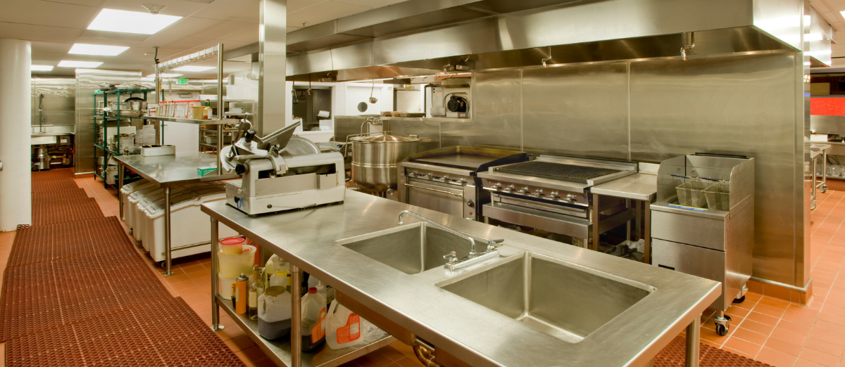 Commercial kitchen with sinks, fryer, work space, deli slices, etc. 