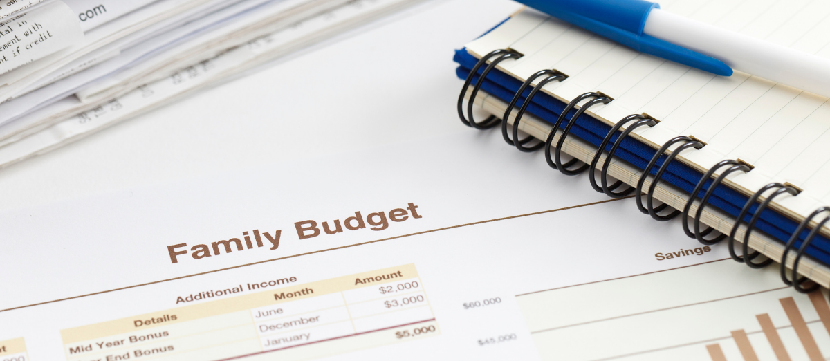 Pen, notebook and printout of family budget