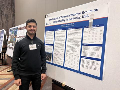 Graduate Student Munib Inam standing next to his poster, "The Impact of Extreme Weather Events on Water Quality in Kentucky, USA"