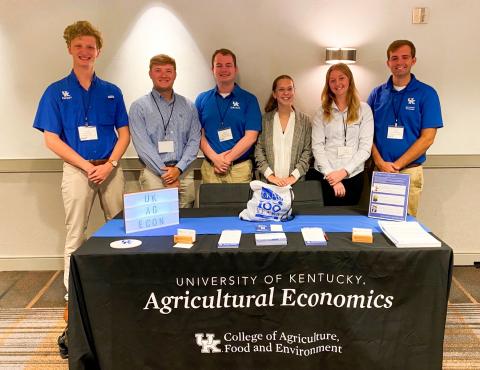 Academic team photo at AAEA Annual Meeting in 2022 standing behind UK Ag Econ recruitment table